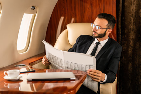 Handsome businessman wearing elegant suit flying on exclusive private jet - Successful entrepreneur...