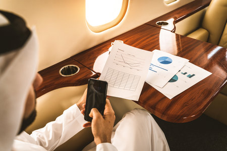 Arabic man wearing kandora in emirates style flying on exclusive private jet - Middle-eastern...