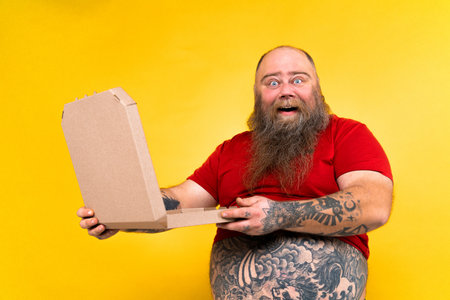 Funny and hilarious fat man hungry for unhealthy foodの写真素材