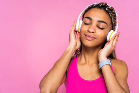 Beautiful afroamerican woman with pigtails portrait on colored background doing sport exercises -...
