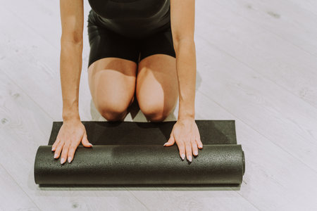 Beautiful athletic woman training in a gym, doing stretching exercises before the workout - Pretty young girl training aloneの写真素材