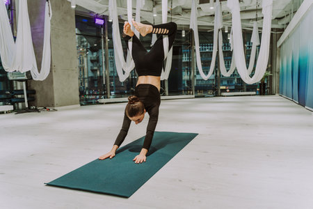 Beautiful athletic woman training in a gym, doing stretching exercises before the workout - Pretty...