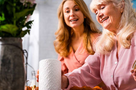 Beautiful senior woman and daughter baking in the kitchen - Grandmother preparing desserts at home with family, concepts about cooking and healthy eatingの写真素材