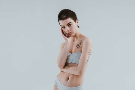 Image of a beautiful woman posing in studio wearing lingerie. Concept about body positivity and self acceptanceの写真素材