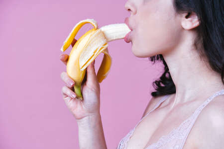 Image of a beautiful woman eating fruit on the profile viewの写真素材