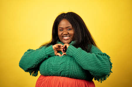 image of a beautiful woman posing in casual clothes on a yellow backgroundの写真素材