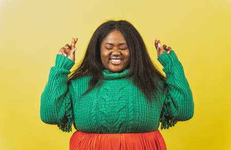 image of a beautiful woman posing in casual clothes on a yellow backgroundの写真素材