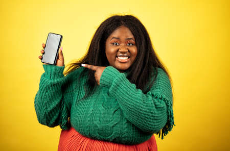 image of a beautiful woman posing in casual clothes on a yellow backgroundの写真素材