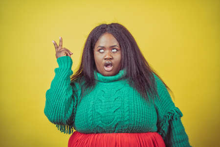 Image of a beautiful woman posing in casual clothes on a yellow backgroundの写真素材