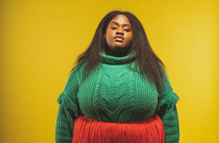 image of a beautiful woman posing in casual clothes on a yellow backgroundの写真素材