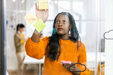 Business company employee brainstorming new ideas for marketing plan - Entrepreneur with colored smart casual clothes working alone in a start-up officeの写真素材