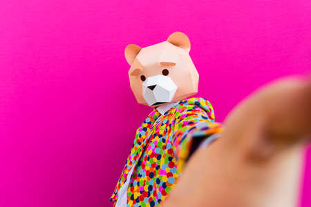 Happy man with funny low poly mask on colored background - Creative conceptual idea for advertising, adult with low-poly origami paper mask doing funny posesの写真素材