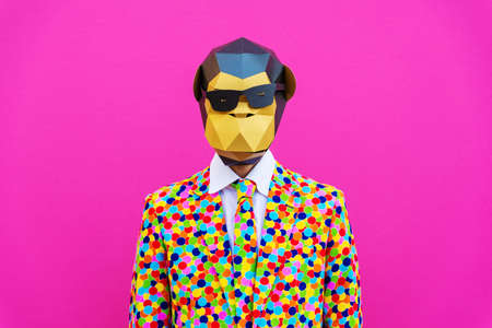 Happy man with funny low poly mask on colored background - Creative conceptual idea for advertising, adult with low-poly origami paper mask doing funny posesの写真素材