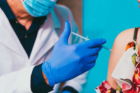 vaccination campaign in a clinic - People getting vaccinated from doctor and nurse to prevent  virus outbreak in a vaccination pointの写真素材