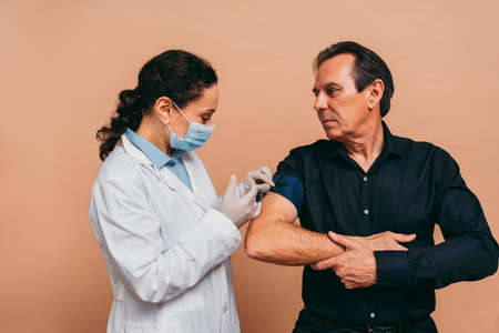 vaccination campaign in a clinic - People getting vaccinated from doctor and nurse to prevent  virus outbreak in a vaccination pointの写真素材