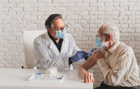 vaccination campaign in a clinic - People getting vaccinated from doctor and nurse to prevent  virus outbreak in a vaccination pointの素材 [FY310169541364]