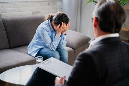 Woman with depression and relationship problems - Psychoterapist studio, psychologist on a session with patientの写真素材
