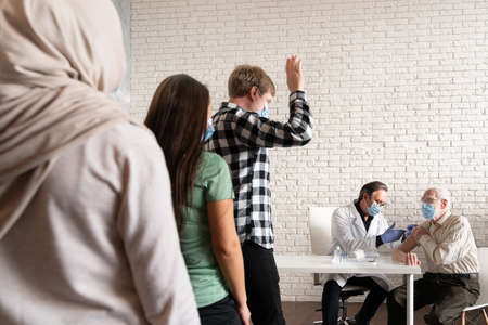 Covid-19 (coronavirus) vaccination campaign in a clinic - People getting vaccinated from doctor and...
