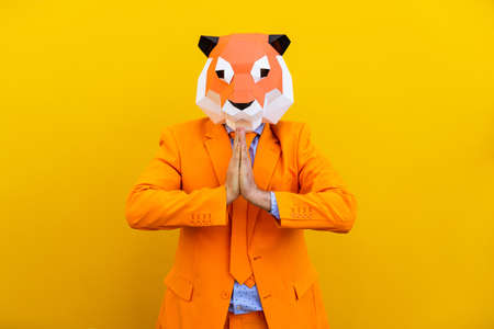Cool man wearing 3d origami mask with stylish colored clothes - Creative concept for advertising, animal head mask doing funny things on colorful backgroundの写真素材