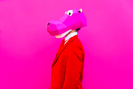Cool man wearing 3d origami mask with stylish colored clothes - Creative concept for advertising, animal head mask doing funny things on colorful backgroundの写真素材