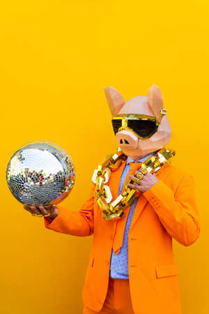 Cool man wearing 3d origami mask with stylish colored clothes - Creative concept for advertising, animal head mask doing funny things on colorful backgroundの写真素材