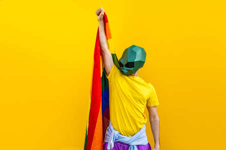 Cool man wearing 3d origami mask with stylish colored clothes - Creative concept for advertising, animal head mask doing funny things on colorful backgroundの写真素材