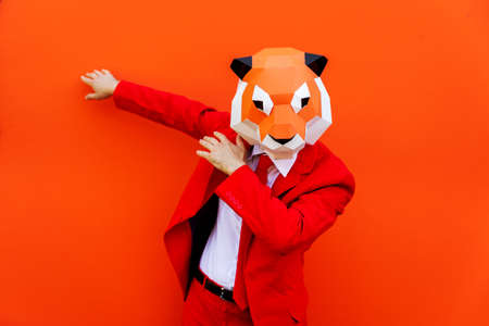 Cool man wearing 3d origami mask with stylish colored clothes - Creative concept for advertising, animal head mask doing funny things on colorful backgroundの写真素材