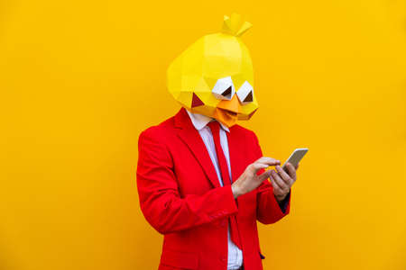 Cool man wearing 3d origami mask with stylish colored clothes - Creative concept for advertising, animal head mask doing funny things on colorful backgroundの写真素材