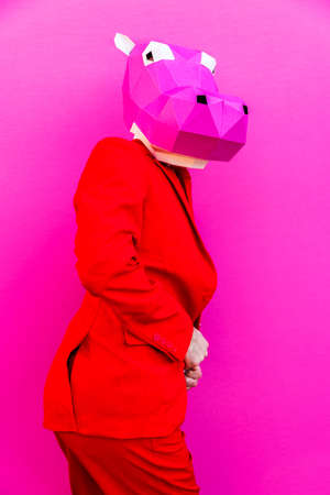 Cool man wearing 3d origami mask with stylish colored clothes - Creative concept for advertising, animal head mask doing funny things on colorful backgroundの写真素材