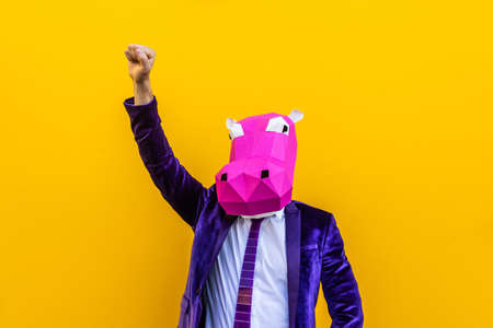 Cool man wearing 3d origami mask with stylish colored clothes - Creative concept for advertising, animal head mask doing funny things on colorful backgroundの写真素材