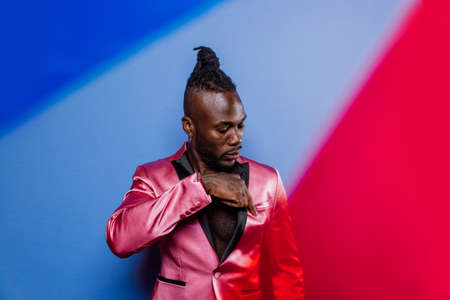 Artistic portrait with gel lights. Handsome man posing on colored backgroundsの写真素材