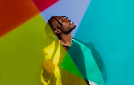 Artistic portrait with gel lights. Handsome man posing on colored backgroundsの写真素材