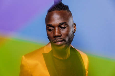 Artistic portrait with gel lights. Handsome man posing on colored backgroundsの写真素材