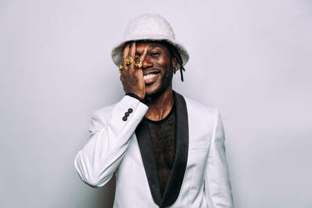 portrait of an hip hop music musician. Cinematic image of a man wearing white clothes and jewelsの写真素材
