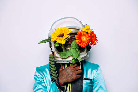 fine art concept with man wearing a space helmet and flowers composition