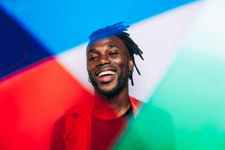 handsome man wearing red leather jacket portrait. Futuristic cyberpunk fashion style. Studio light shot on white backgroundの写真素材