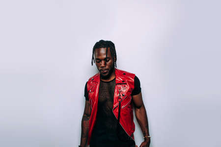 Handsome man wearing red leather jacket portrait. Futuristic cyberpunk fashion style. Studio light shot on white backgroundの写真素材