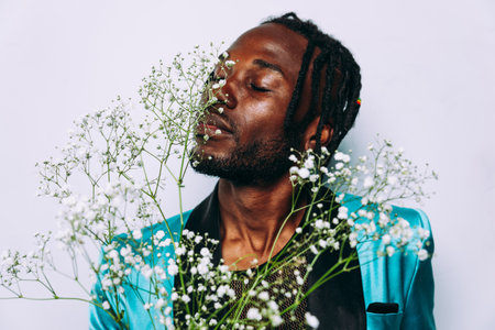 fine art concept of a man smelling white flowers. Elegant dressed man with floreal compositionの写真素材