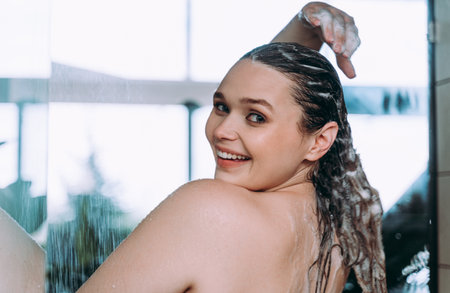 lifestyle moments of a young woman at home. Woman taking a shower in the morningの写真素材