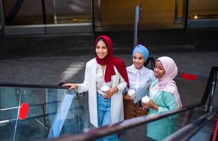Multiethnic group of muslim girls wearing casual clothes and traditional hijab bonding and having fun outdoors - 3 arabic young girlsの写真素材