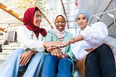 Multiethnic group of muslim girls wearing casual clothes and traditional hijab bonding and having fun outdoors - 3 arabic young girlsの写真素材