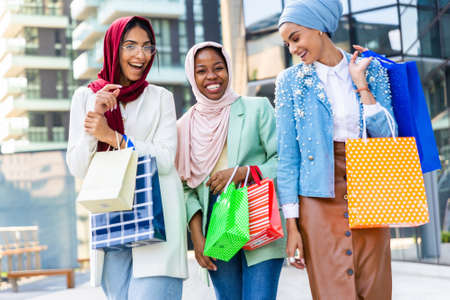 Multiethnic group of muslim girls wearing casual clothes and traditional hijab bonding and having fun outdoors - 3 arabic young girlsの写真素材