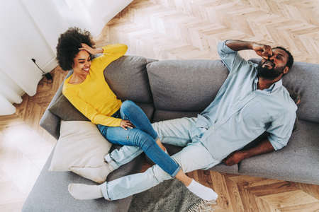 Beautiful afro-american couple relax on the sofa at home - Domestic life, cheerful couple bonding...
