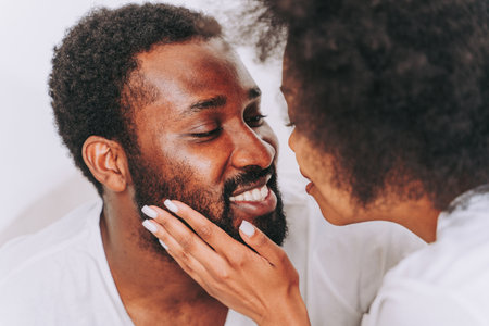 Afro american couple in bed - Real beautiful and cheerful pair of lovers at homeの写真素材