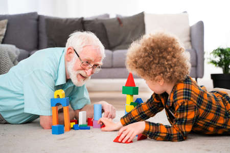 Grandparents and grandson playing at home - Family at home, grandfather taking care of nephewの写真素材