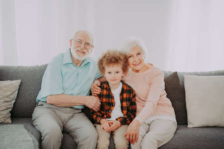 Grandparents and grandson playing at home - Family at home, grandmother and grandfather taking care of nephewの写真素材