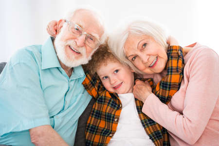 Grandparents and grandson playing at home - Family at home, grandmother and grandfather taking care of nephewの写真素材