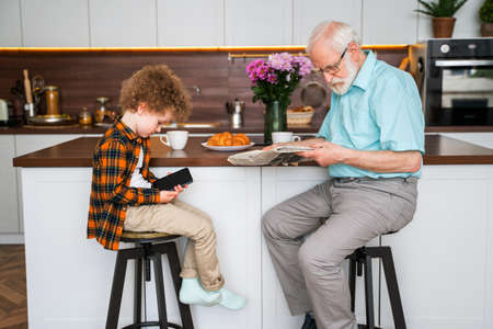 Grandparents and grandson playing at home - Family at home, grandfather taking care of nephewの写真素材