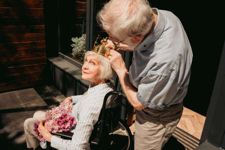 Disabled old woman on wheel chair - Senior couple at home, partner coming back from hospital in convalescenceの写真素材
