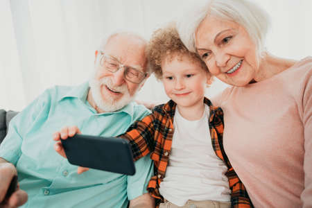 Grandparents and grandson playing at home - Family at home, grandmother and grandfather taking care...